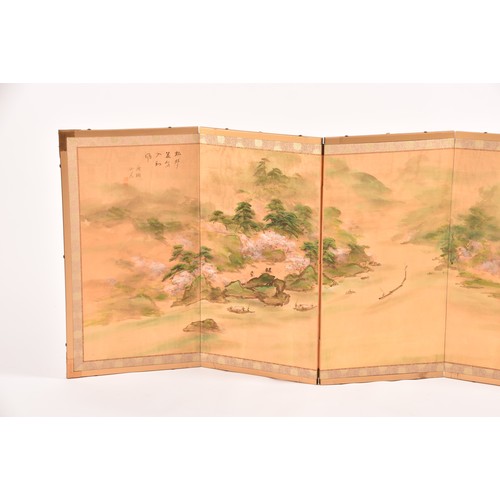 53 - A Japanese silk table top or wall hanging four fold screen, painted with an extensive landscape scen... 