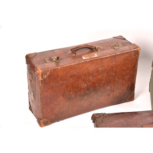 248 - A group of two leather, one alligator skin and one canvas covered suitcases / trunks, the canvas cov... 