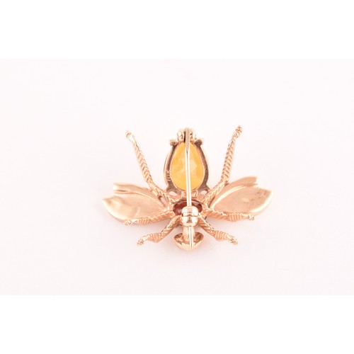 111 - A 9ct yellow gold brooch in the form of an insect, set with a garnet and citrine, having textured wi... 