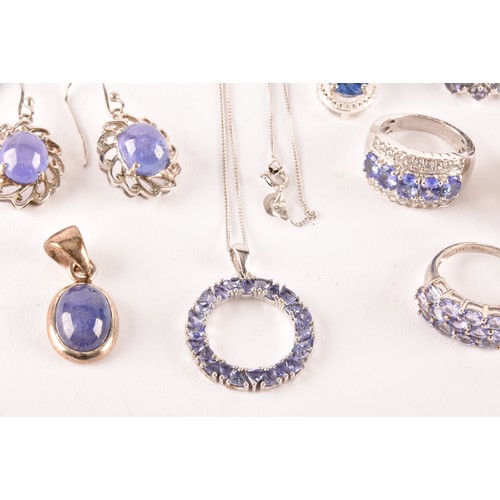 128 - A silver and tanzanite halo pendant on chain, together with a silver and cabochon tanzanite pendant,... 