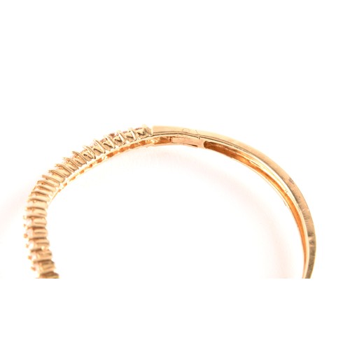 137 - A yellow gold and diamond bangle, of waved design, set with twenty-five round brilliant-cut diamonds... 