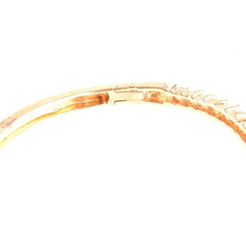 137 - A yellow gold and diamond bangle, of waved design, set with twenty-five round brilliant-cut diamonds... 