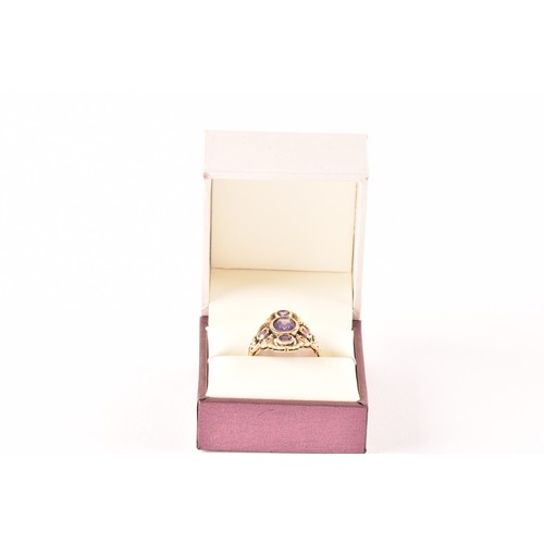 139 - A 9ct yellow gold and amethyst ring, collet set with mixed oval-cut and round-cut amethysts, the sty... 