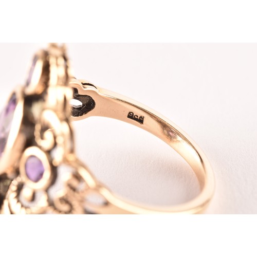 139 - A 9ct yellow gold and amethyst ring, collet set with mixed oval-cut and round-cut amethysts, the sty... 