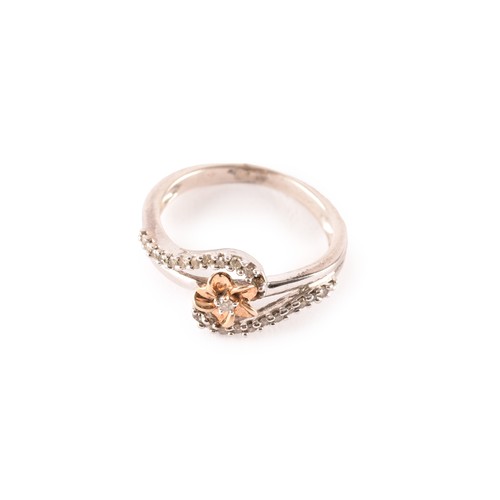 142 - A white gold and diamond crossover ring, centred with a yellow gold flower motif, and two rows of ro... 