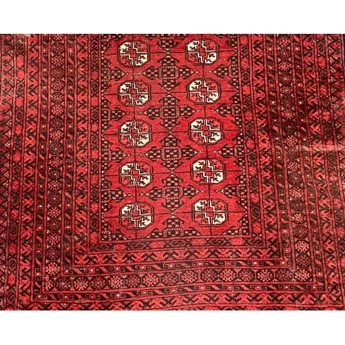 294 - A Persian rug intricately patterned red and black, with highlights of white, fringed edges, 187 x 13... 