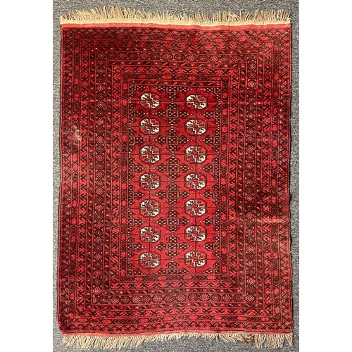 294 - A Persian rug intricately patterned red and black, with highlights of white, fringed edges, 187 x 13... 