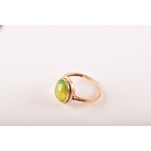 154 - An unusual 9ct yellow gold and opal ring, the oval cabochon opal showing strong green and orange pla... 