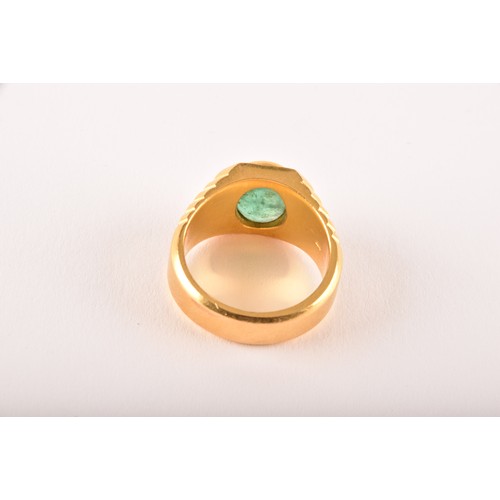 156 - A high carat yellow gold and emerald gents ring, set with an oval polished cabochon emerald, within ... 