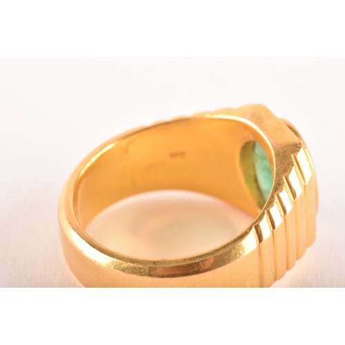 156 - A high carat yellow gold and emerald gents ring, set with an oval polished cabochon emerald, within ... 