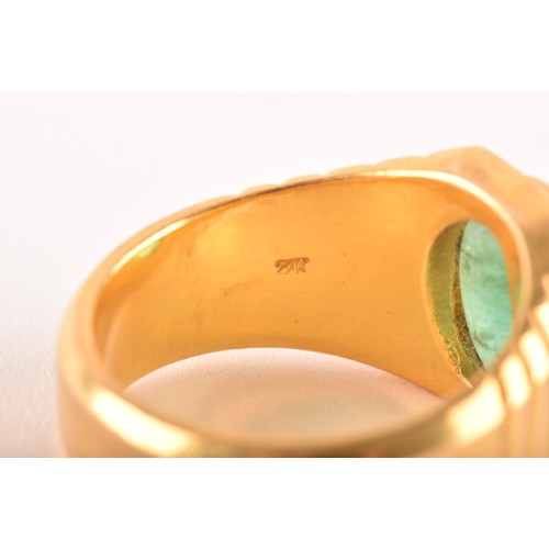 156 - A high carat yellow gold and emerald gents ring, set with an oval polished cabochon emerald, within ... 