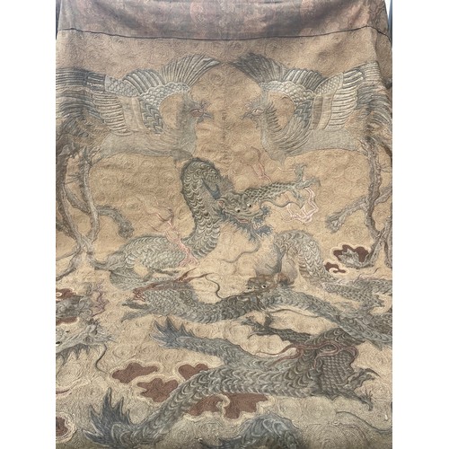 19 - A large antique Chinese silk needlework tapestry wall hanging, decorated with give dragons chasing a... 