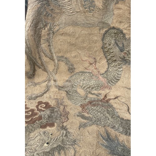 19 - A large antique Chinese silk needlework tapestry wall hanging, decorated with give dragons chasing a... 