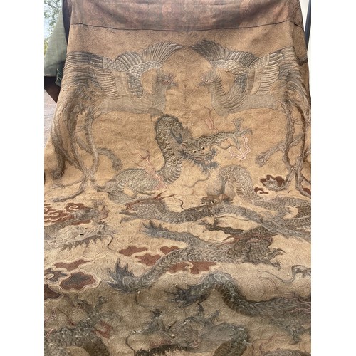 19 - A large antique Chinese silk needlework tapestry wall hanging, decorated with give dragons chasing a... 