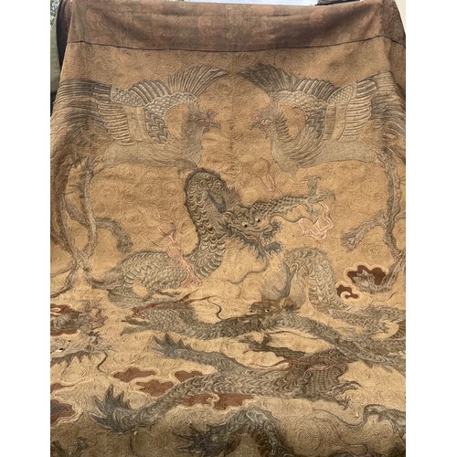 19 - A large antique Chinese silk needlework tapestry wall hanging, decorated with give dragons chasing a... 