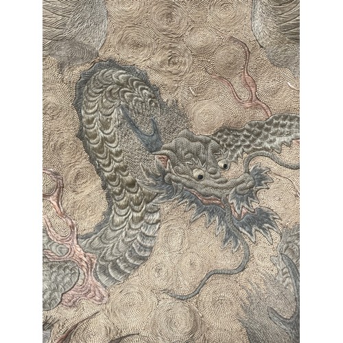 19 - A large antique Chinese silk needlework tapestry wall hanging, decorated with give dragons chasing a... 