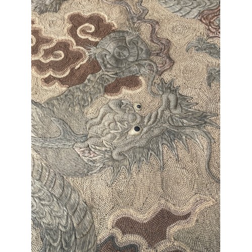 19 - A large antique Chinese silk needlework tapestry wall hanging, decorated with give dragons chasing a... 