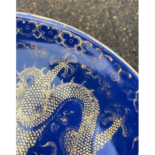 13 - A Chinese Qing Dynasty blue glaze and gilt porcelain dragon pattern dish, a pair of dragons with the... 