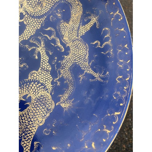 13 - A Chinese Qing Dynasty blue glaze and gilt porcelain dragon pattern dish, a pair of dragons with the... 