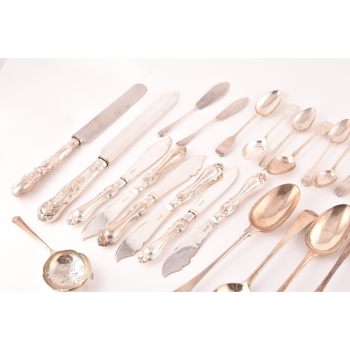 111 - A collection of Georgian and Victorian silver cutlery, to include an array of spoons, knives, a tea ... 