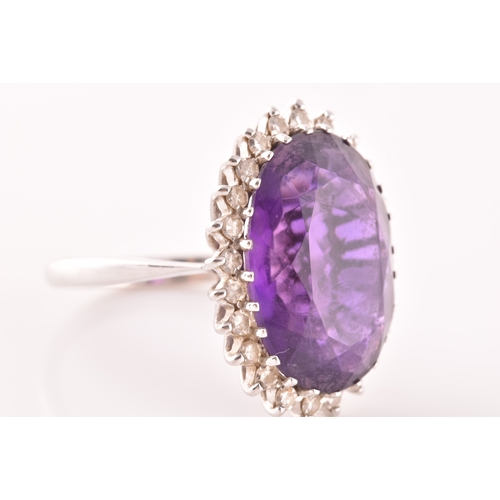 7 - A 18ct white gold amethyst and diamond coronet cluster ring, set to centre with a oval cut amethyst ... 