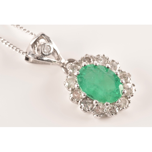 14 - An 18ct white gold emerald and diamond pendant and chain, featuring a oval cut emerald with an appro... 