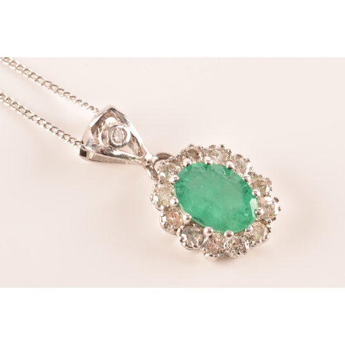 14 - An 18ct white gold emerald and diamond pendant and chain, featuring a oval cut emerald with an appro... 