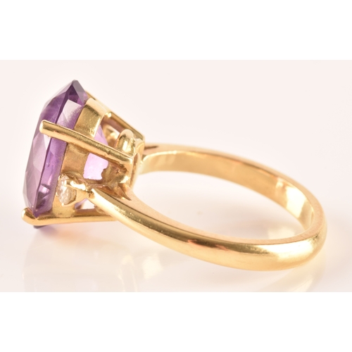 10 - A 18ct yellow gold amethyst and diamond flanked solitaire, set with an oval cut amethyst with a appr... 