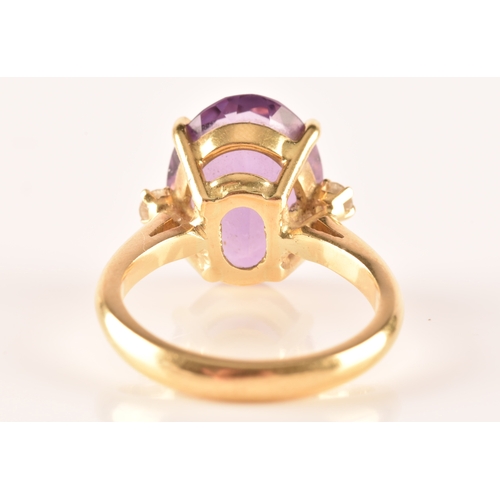 10 - A 18ct yellow gold amethyst and diamond flanked solitaire, set with an oval cut amethyst with a appr... 