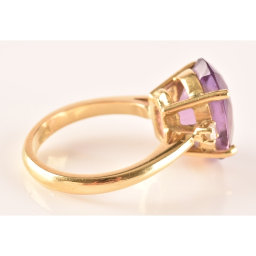 10 - A 18ct yellow gold amethyst and diamond flanked solitaire, set with an oval cut amethyst with a appr... 