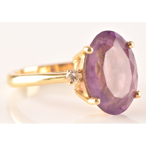 10 - A 18ct yellow gold amethyst and diamond flanked solitaire, set with an oval cut amethyst with a appr... 