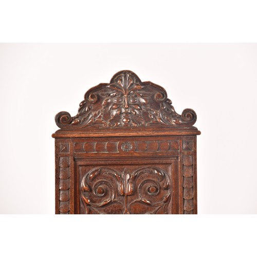 291 - An 19th century carved oak armchair, the back carved with the bust of the green man, above a panel c... 