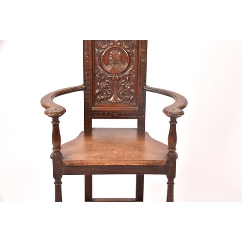 291 - An 19th century carved oak armchair, the back carved with the bust of the green man, above a panel c... 