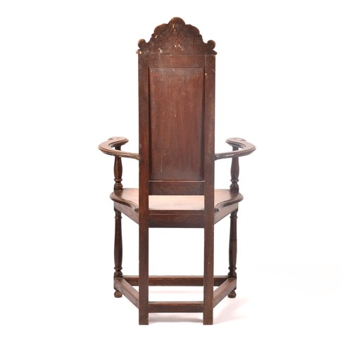 291 - An 19th century carved oak armchair, the back carved with the bust of the green man, above a panel c... 