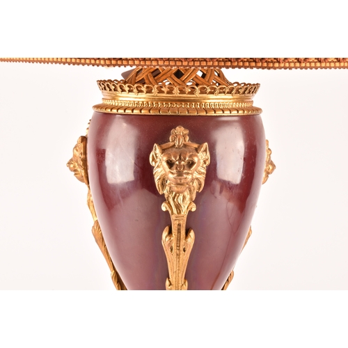 254 - A 19th century French Ormolu table lamp, the oxblood red painted enamel with gilt lion decoration on... 