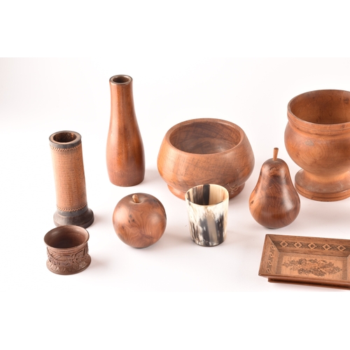 256 - A collection of assorted carved wooden treen items, including vases, cups, bowls, carved fruit, a ca... 