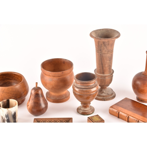 256 - A collection of assorted carved wooden treen items, including vases, cups, bowls, carved fruit, a ca... 