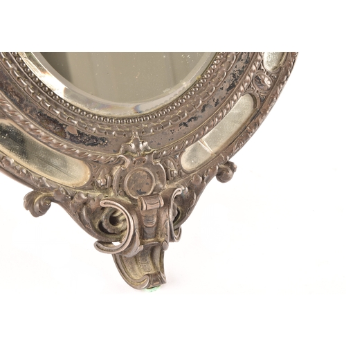 298 - A Victorian metal oval easel mirror, the elaborate frame with scrolled and engraved decoration, with... 