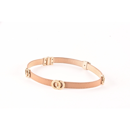 13 - Bulgari. A tan leather double coiled wrap bracelet with gold tone hardware, the interlocking rings f... 