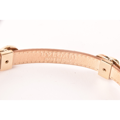 13 - Bulgari. A tan leather double coiled wrap bracelet with gold tone hardware, the interlocking rings f... 