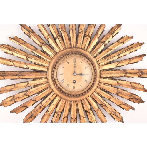 277 - An Art Deco starburst wall clock, with gold roman numeral dial, gilt wood, 55cm wide x 41 cm high.