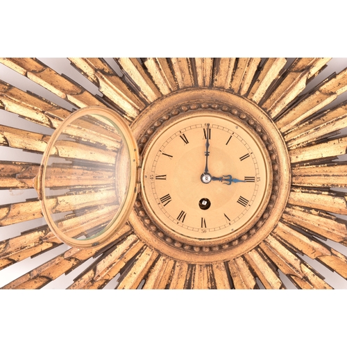 277 - An Art Deco starburst wall clock, with gold roman numeral dial, gilt wood, 55cm wide x 41 cm high.