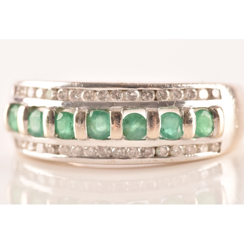 18 - A 14ct white gold ring featuring seven round cut emeralds with a combined approximate weight of 0.35... 