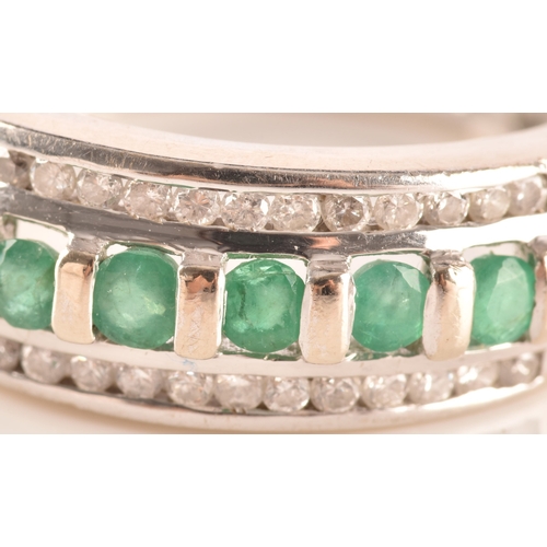 18 - A 14ct white gold ring featuring seven round cut emeralds with a combined approximate weight of 0.35... 