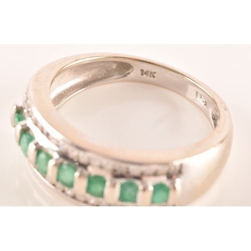 18 - A 14ct white gold ring featuring seven round cut emeralds with a combined approximate weight of 0.35... 