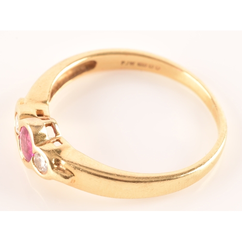 21 - An 18 carat yellow gold ruby and diamond three stone ring, set to centre with a oval ruby with an ap... 