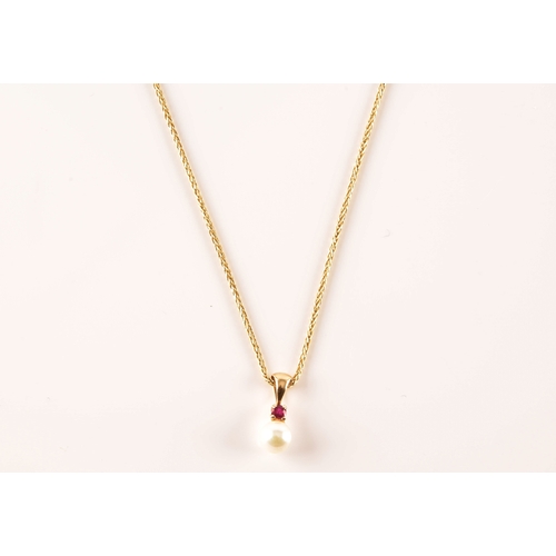 22 - A 14ct yellow gold pendant and chain, featuring a pearl suspended from a round cut ruby, accompanied... 