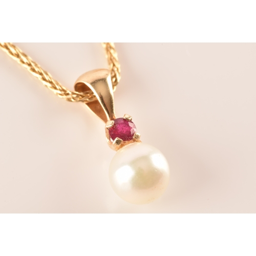 22 - A 14ct yellow gold pendant and chain, featuring a pearl suspended from a round cut ruby, accompanied... 