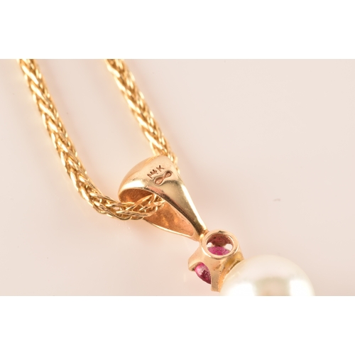 22 - A 14ct yellow gold pendant and chain, featuring a pearl suspended from a round cut ruby, accompanied... 