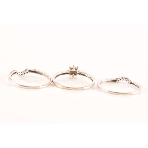 28 - A set of three 9ct white gold and diamond rings, to include a floral ring set with seven round brill... 